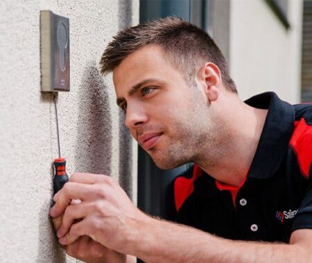 SafeTeam-tekniker skruvar på en läsare i ett passersystem.