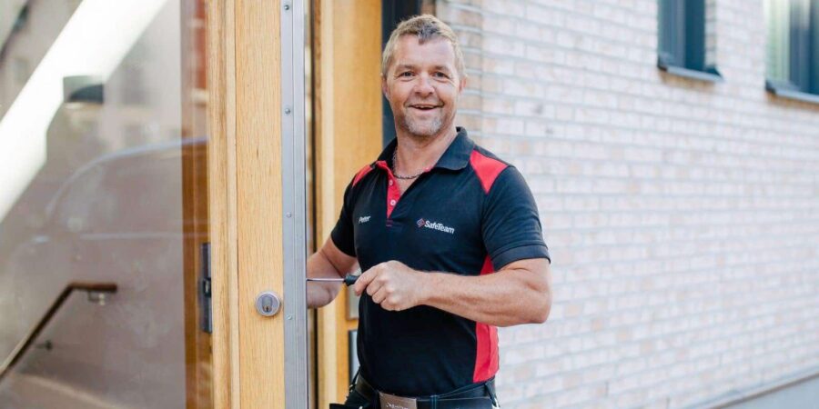 Låstekniker skruvar på ett lås vid en dörr