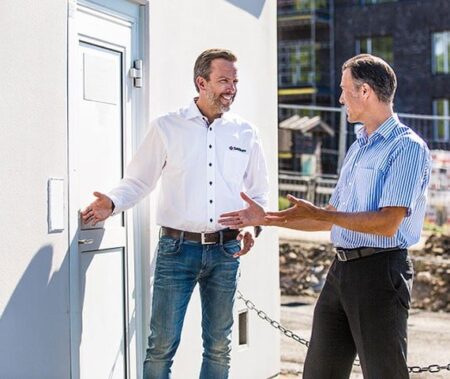 SafeTeam-anställd visar säkerhetslösningar på platsbesök på en byggarbetsplats.