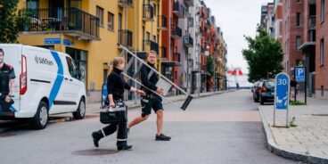 Säkerhetstekniker från SafeTeam går över gata med fastigheter och företag.