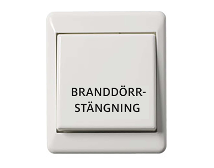 Stängningsknapp för branddörrstängning, vid tryck släpper hållmagneten och branddörren stängs.