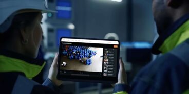 En säkerhetslösning med bevakningskameror från Hanwha i industrimiljö där personal följer övervakningsbilder på en surfplatta/tablet | SafeTeam