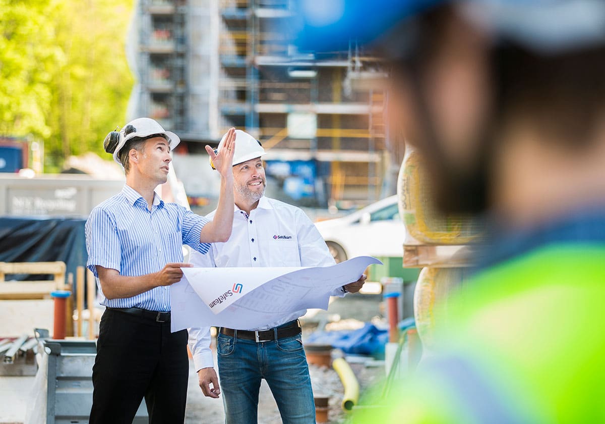 Projektör från SafeTeam tillsammans med kund på en byggarbetsplats.