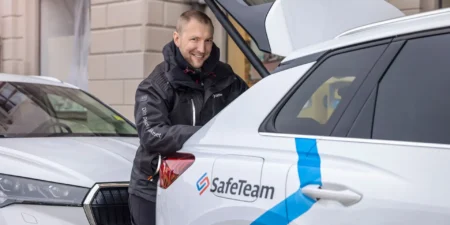 Tekniker från SafeTeam vid sin bil med öppen bagagelucka där han hämtar verktyg inför en installation av säkerhetsteknik.