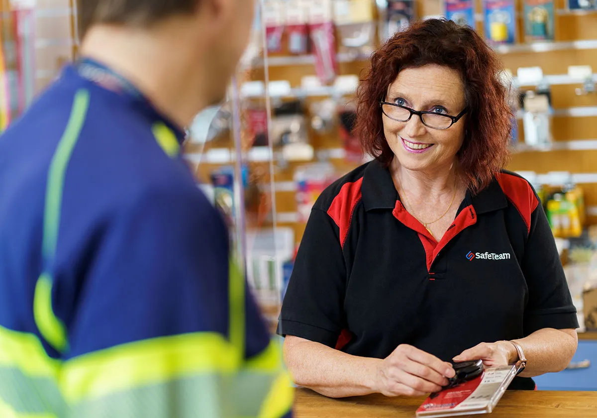 Låssmed Stockholm hjälper en kund med ett lås i låsbutiken i Stockholm.