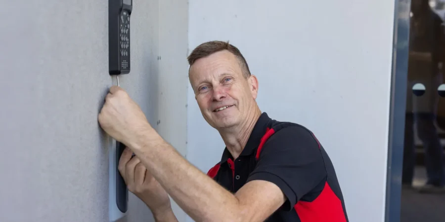 En säkerhetstekniker från SafeTeam installerar ett passersystem i ett flerfamiljshus.