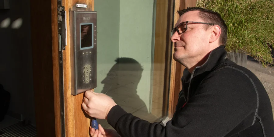 En installationstekniker monterar en porttelefon från Aptus hos en brf.